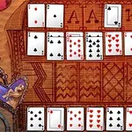 Rozložené herné karty na drevenom stole s rôznymi symbolmi a ornamentmi
