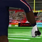 Futbalový hráč v tmavom drese odkopáva loptu cez bránkovú konštrukciu na plnom štadióne