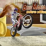 Motocyklista na jednom kolese jazdí po pracovnom stole vedľa klávesnice, monitora a rozliateho hrnčeka s kávou