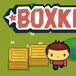 Dve drevené debny, postavička s hnedými vlasmi a červeným tričkom na zelenej lúke s nápisom BOXKID