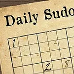 Papier so sudoku hádankou, perom a pierkom v rohu