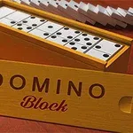 Drevená krabica s dominovými kockami a odklopiteľným vrchnákom s nápisom Domino Block na červenom povrchu