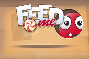 Nápis Feed Me s červenou guľou a cukríkom na béžovom pozadí