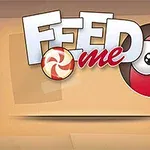 Nápis Feed Me s červenou guľou a cukríkom na béžovom pozadí