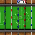 Stolný futbal zhora s červenými a modrými figúrkami na zelenom ihrisku