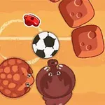 Futbalová lopta obklopená zvieracími postavičkami na pieskovom ihrisku s červenými kameňmi