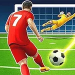 Futbalista v červenom drese kope loptu do brány, zatiaľ čo brankár v žltom skáče, aby loptu chytil