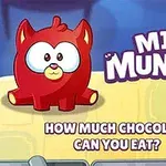 Červený kreslený tvor s veľkými očami pri čokoláde a nápisom MINI MUNCHER na žlto-modrom pozadí