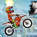 Motocyklista v oranžovo-zelenom oblečení skáče na dirt bikeri pred zasneženou krajinou s vianočným stromčekom