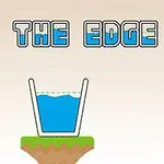 Pohár s modrou tekutinou stojaci na okraji zelenej plošiny s nápisom ON THE EDGE