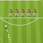 Hráči futbalového tímu stoja v bariére na ihrisku, pričom lopta sa blíži k nim po zakrivenej trajektórii