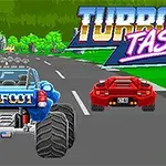 Modrá monster truck s nápisom BIGFOOT a červené športové auto na pretekárskej dráhe s logom TURBO TASTIC na pozadí
