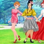 Tri ženy v elegantných šatách pózujú v parku