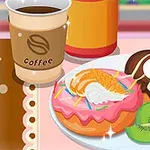 Šálka kávy vedľa taniera s dvoma donutama ozdobenými ovocím a polevami